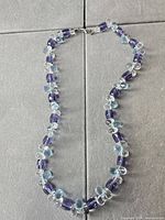 Full view of glass bead necklace showing bead colors, arrangement and clasp