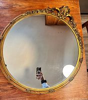 Full view of round gold mirror on table