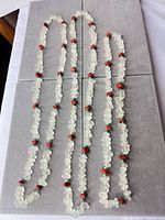 Three frosted sea glass, red and green chip bead necklaces laid out