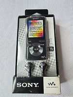 Front view of Sony NWZ-E385 MP3 player in original box with earbuds visible