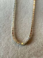 Close-up of sterling silver box chain necklace showing square links and silver finish