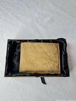 wallet resting inside gift box, suede texture visible