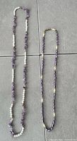Both necklaces full length on tile surface