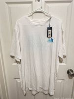 Front view of white Vineyard Vines tee with tag and small golfer graphic