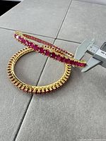 Close-up of both bangles showing stone settings and caliper confirming inner diameter