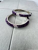 Two purple rhinestone bangles stacked showing exterior crystal coverage