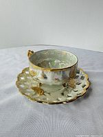 Teacup on saucer showing exterior design and feet