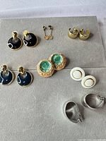 All seven earring pairs laid out on gray board