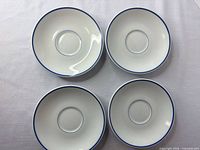 Top view of all four plates showing white porcelain and blue rim