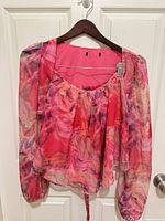 Front view of abstract swirl chiffon blouse on hanger