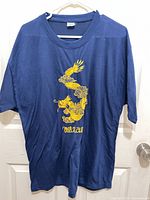 Front view of navy T-shirt displaying yellow embroidered dragon and "Vietnam" text