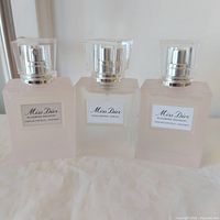 Front view of all three Miss Dior bottles—two Blooming Bouquet Hair Mists and one Hair Oil—showing full fill levels and labels
