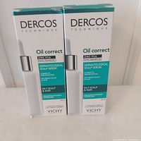Front view of two boxed Vichy Dercos Oil Correct Scalp Serum bottles