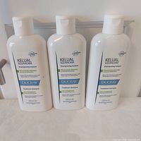 Front view of three Ducray Kelual Squanorm Shampoo bottles
