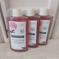 Three sealed 400 ml bottles of Klorane sensitive scalp shampoo front view
