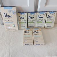 Group shot of seven Nair wax strip boxes showing contents and quantities