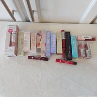 Full group of boxed and unboxed lip products laid out on surface