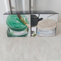 Front view of two sealed Teaology face cream boxes