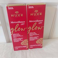 Front view of two sealed Nuxe Merveillance Lift Glow Cream boxes