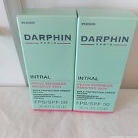 Front view of two sealed Darphin Intral SPF 50 boxes