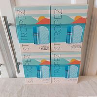Front view of four boxed St. Tropez Self Tan Kit Express sets