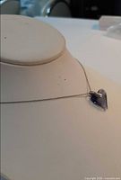 Pendant displayed on necklace form showing heart shape and chain drape
