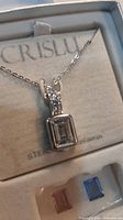 Pendant necklace in original box showing clear crystal insert