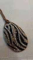 Front view of pendant showing black enamel and rhinestones