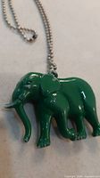 Front view of green elephant pendant on silver-tone chain