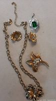 Full lot showing necklace, earrings, brooch, silver-tone green pendant