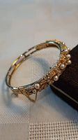 Overall view of gold-tone faux pearl crystal hinged bracelet