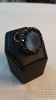 Front view showing blue cabochon and crystal halo