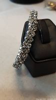 Full view of silver-tone rhinestone stretch bracelet displayed on stand