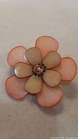 Front view showing six pink translucent petals and rhinestone centre