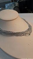 Necklace displayed on bust to show drape and strand layering
