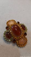 Front view showing amber cabochon centre and surrounding faux citrine crystals