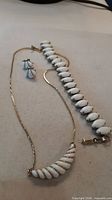 Bracelet, necklace, and earrings laid out together