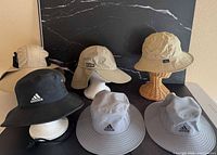 Group shot of all six hats displayed on stands