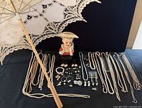 Full lot view showing parasol, head vase, jewellery spread