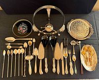Full layout of assorted silverplate trays, stand, flatware and utensils