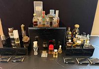 Front view of entire collection on black stands showing quantity and variety of bottles and Dior box