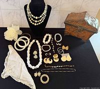 Full view of jewelry lot, handkerchief and trinket chest displayed on table