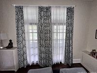 Three slate blue ikat drapery panels with sheer in between on window