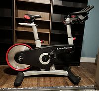 Left side view showing full bike frame, flywheel and base