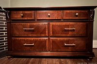Front view showing drawers, hardware, veneer patterns, carved details
