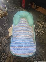 Front view of Infantino baby bouncer seat showing fabric pattern and headrest
