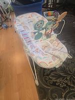 Overall view of bouncer seat showing fabric pattern and frame