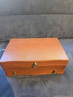 Closed wooden jewelry box front view showing hardware