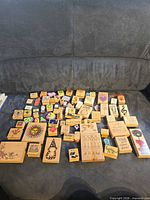Entire lot of 78 assorted wood block stamps displayed on sofa