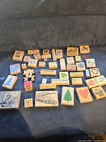 Full group of 44 wood-mounted stamps laid out on sofa